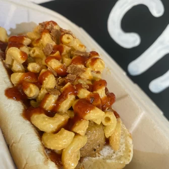 brat topped with bbq sauce and Macno cheese.